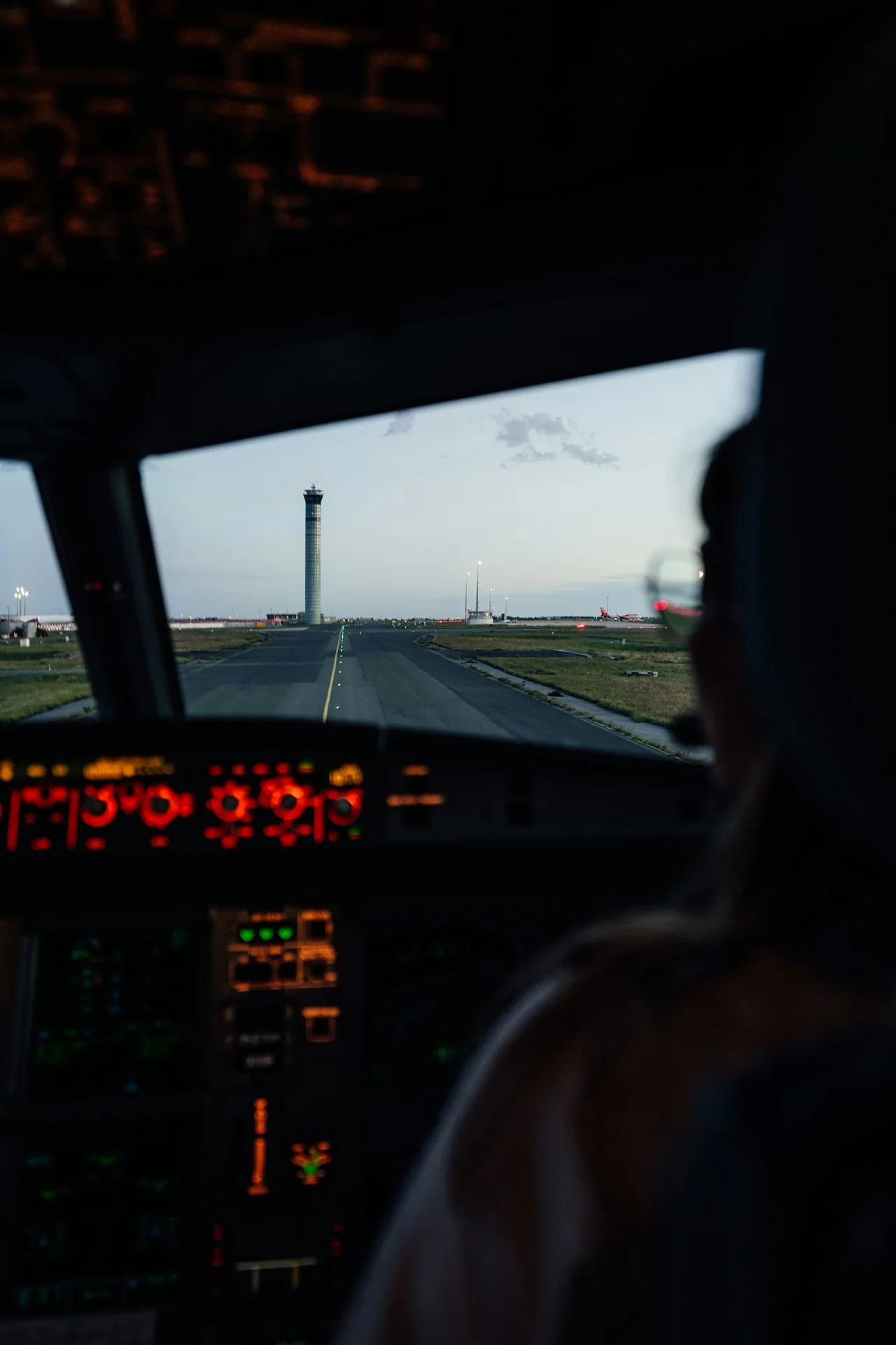 View from a flight deck across the runway toward the control tower in evening light
